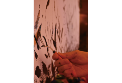 久渡寺に奉納する岩木山画を描き進める井上信平の手には、アクリルの色が飛び散っている